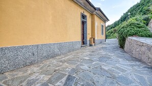 A stone-paved pathway leading to a yellow building with a stone base. - 2 bedroom lovely home in Ne (Ne)