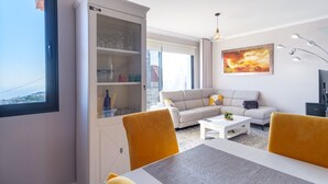 Un salon moderne comprenant un canapé, une table basse et un meuble avec des portes en verre.