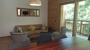Un intérieur en bois comprenant un canapé, des fauteuils, une table et un téléviseur.