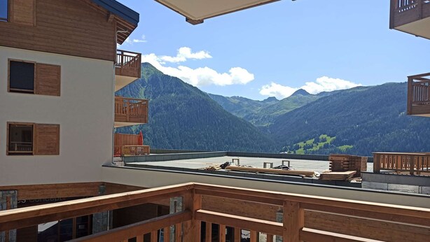 Ein Balkon mit Holellentrailierungen mit Blick auf eine gebirgige Landschaft.