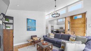 A modern living room with a sofa, coffee table, and a painting on the wall. - 4 Bedroom Luxury in Capitola Village w/ parking! (Capitola)