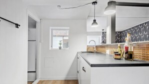 Una cocina moderna con armarios blancos, encimera negra y ventana con vistas.