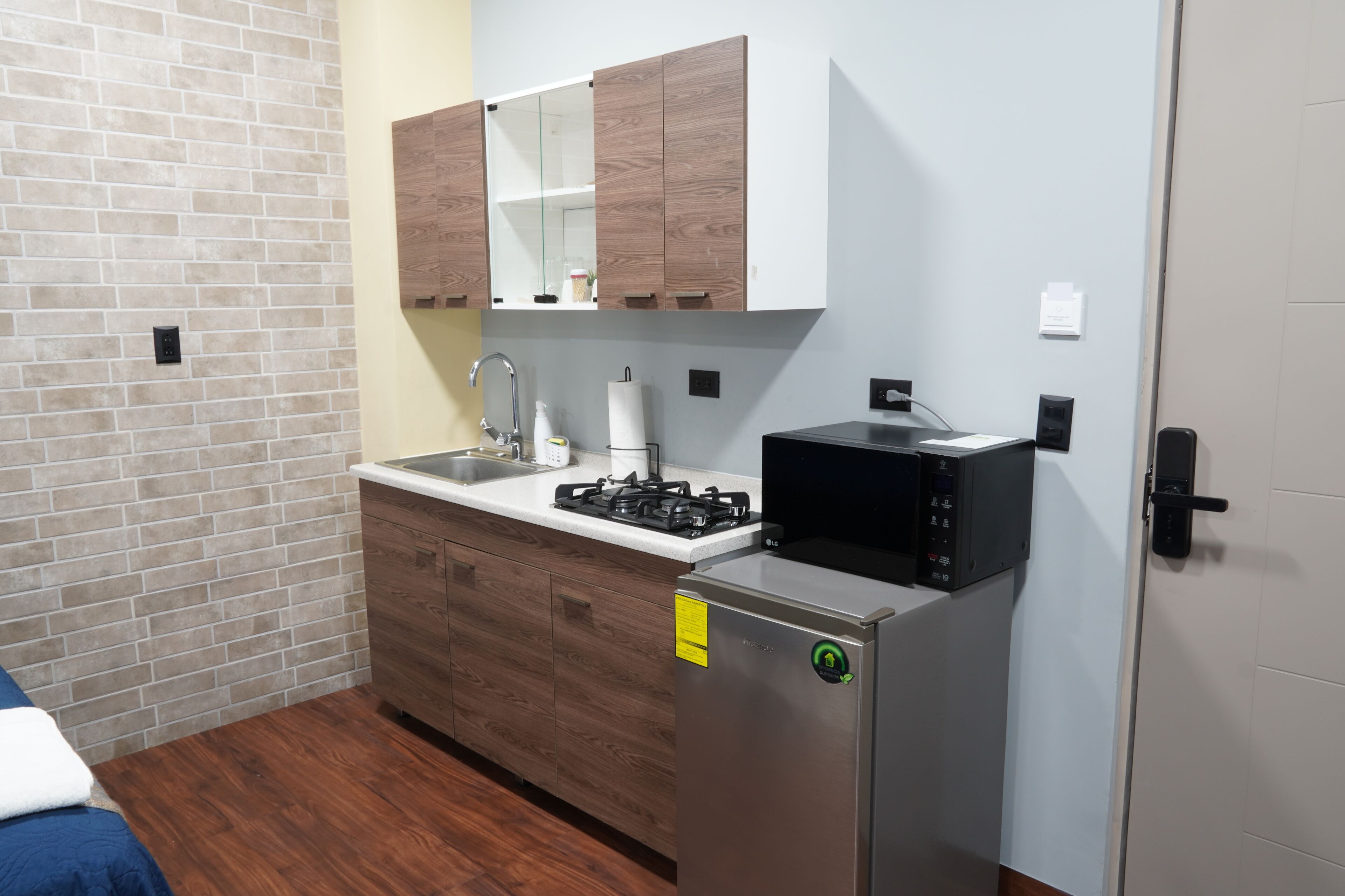 A compact kitchen with a built-in stove, sink, and wooden cabinets.