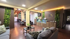 Amplia sala de estar con mostrador de recepción, zonas de estar y un gran acuario.