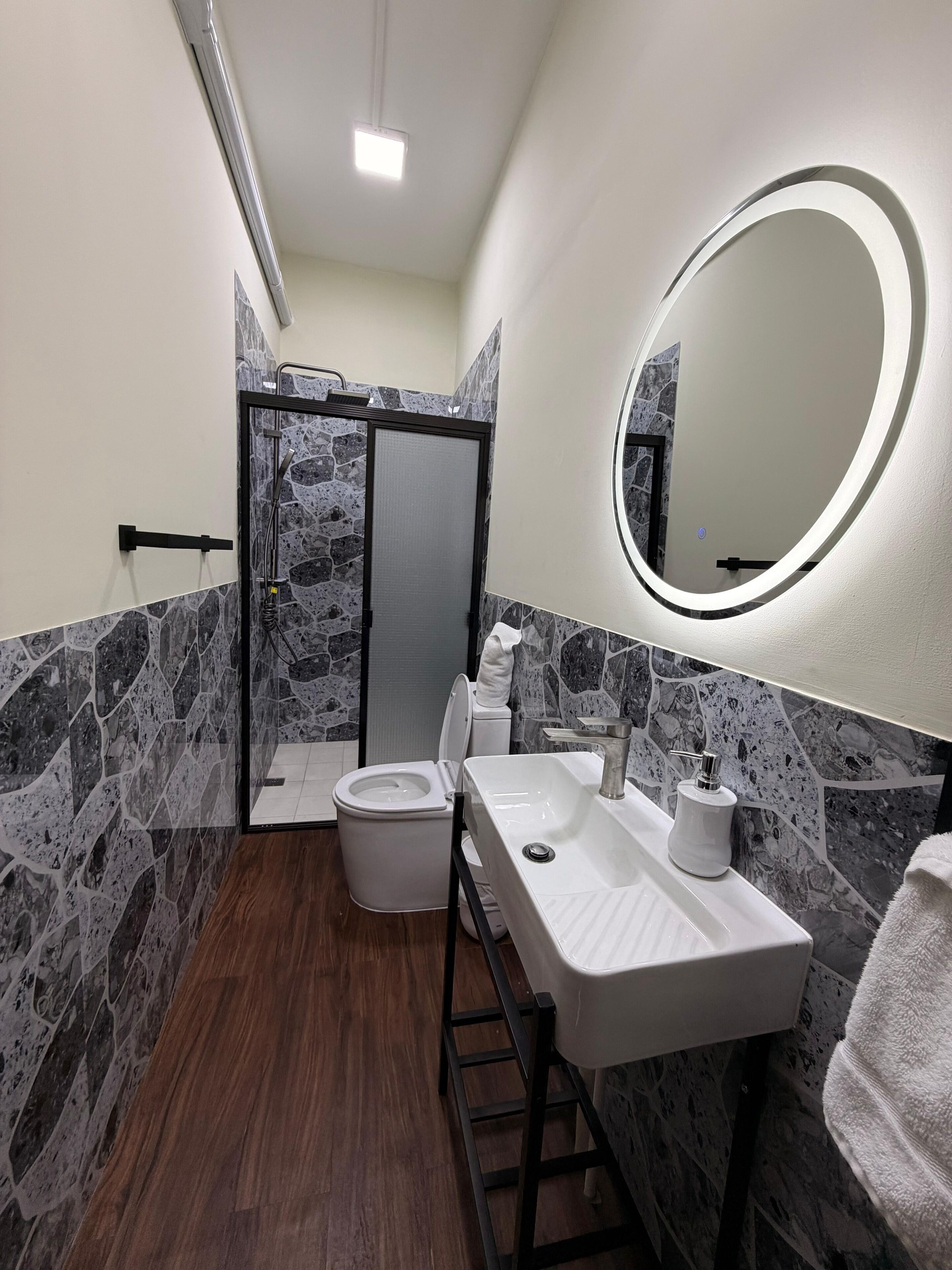 A bathroom with a shower, toilet, and sink.