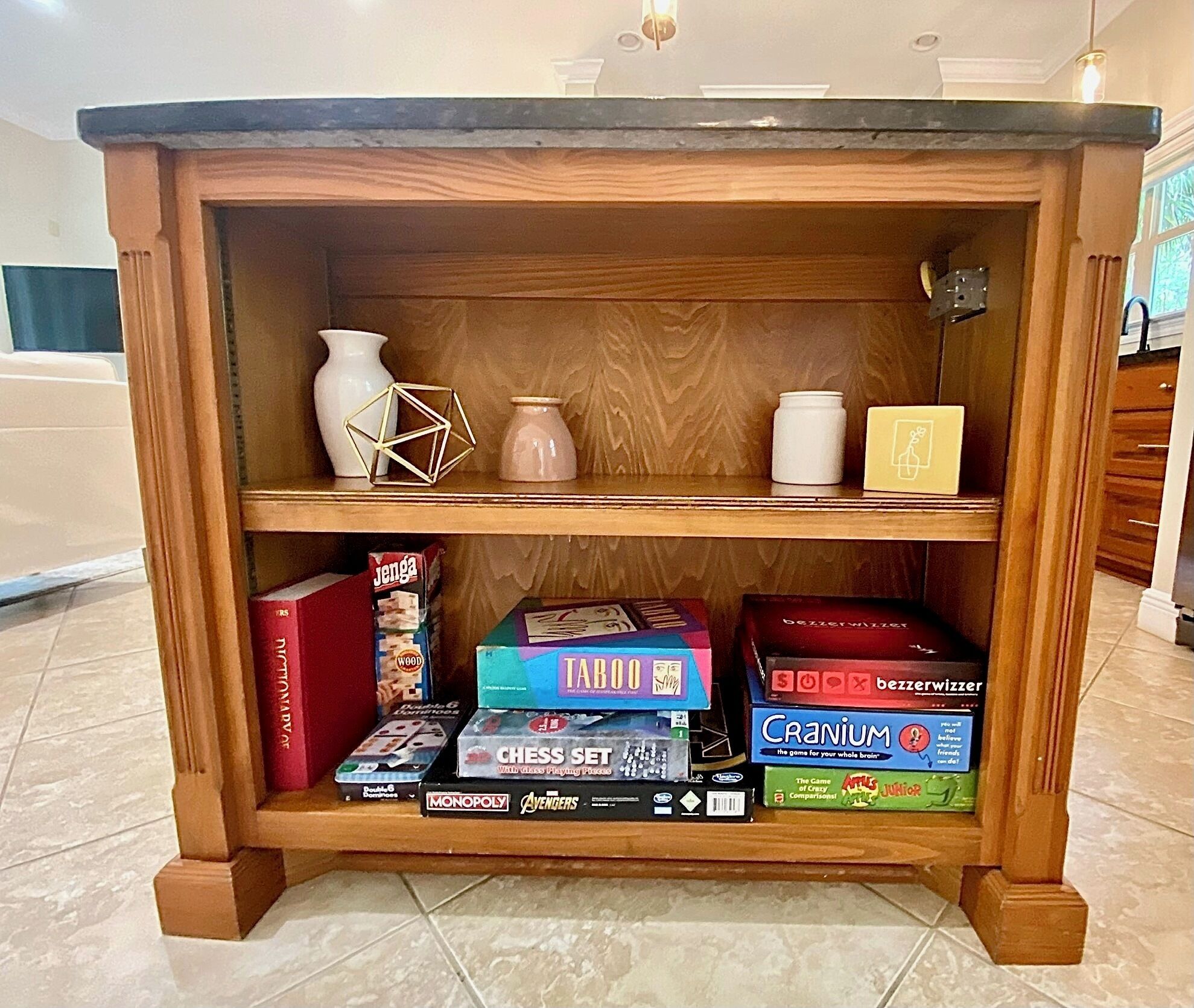 A wooden shelf with various board games and books.