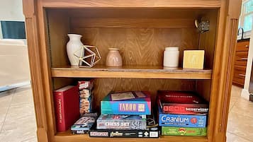 A wooden shelf with various board games and books.
