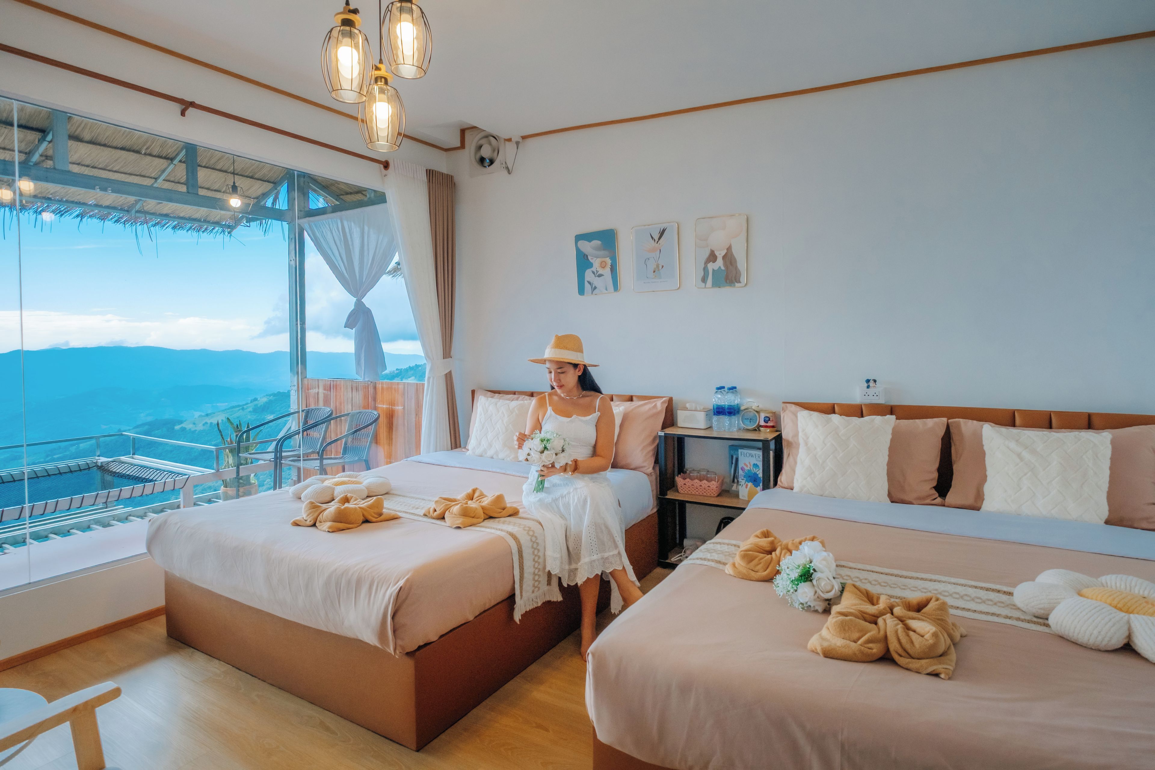 Ein Hotelzimmer mit zwei Betten, einem Balkon mit Blick und einem Essbereich.