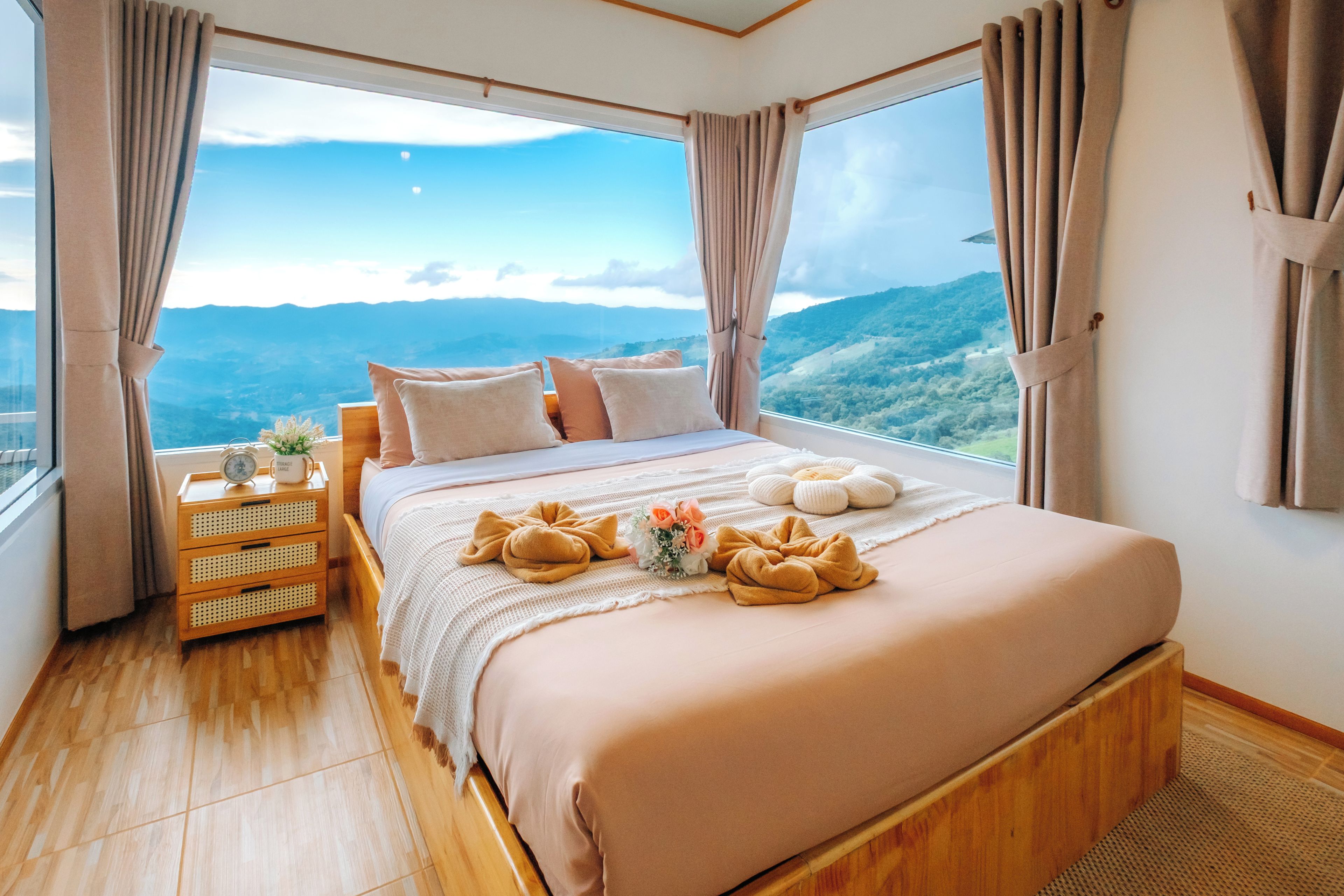 Una camera da letto con un letto grande, comodini in legno e vista sulle montagne.