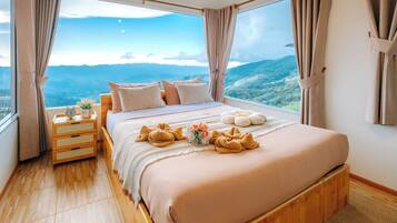 Una camera da letto con un letto grande, comodini in legno e vista sulle montagne.