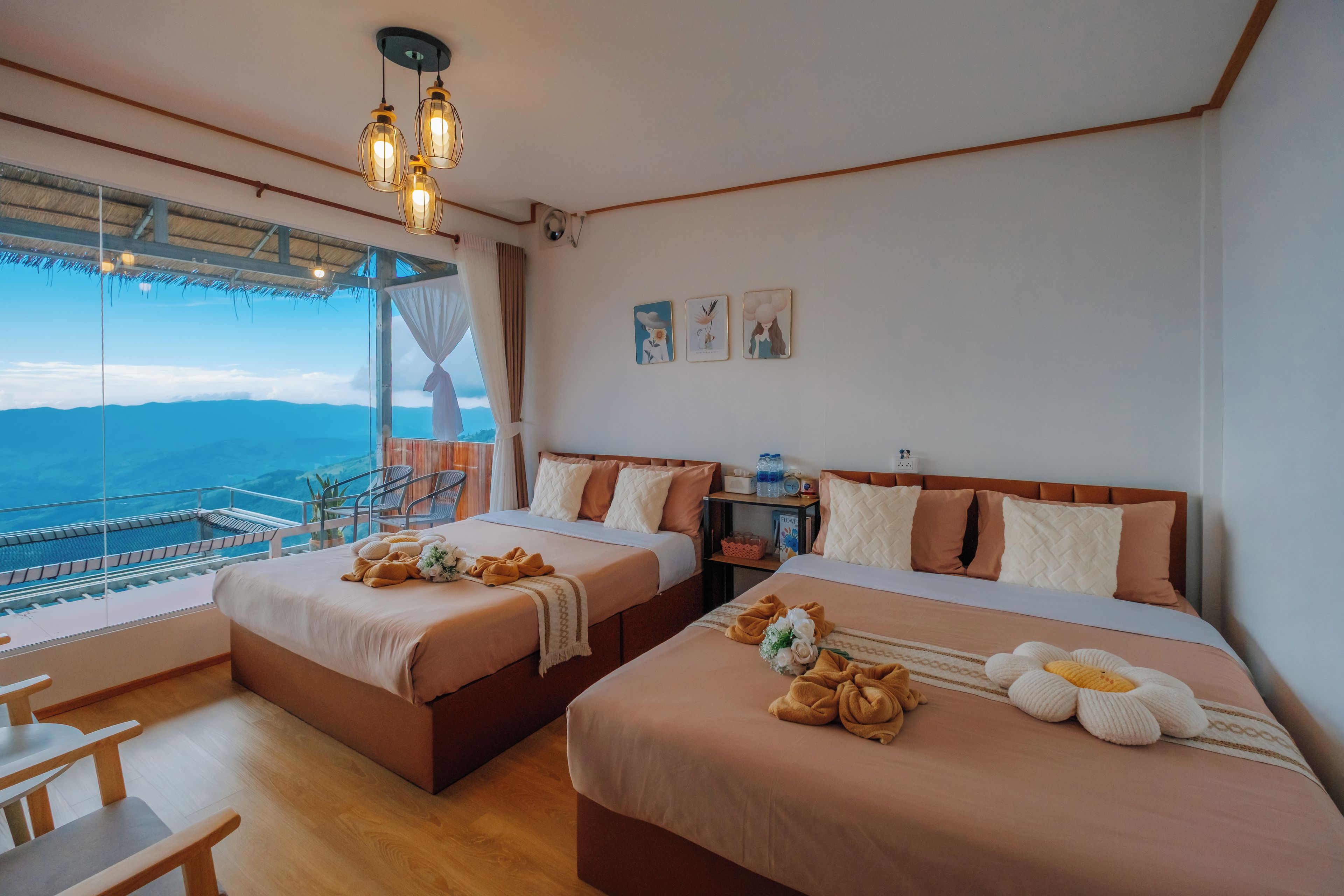 Habitación de hotel con dos camas, vista al océano y un balcón con barandilla.
