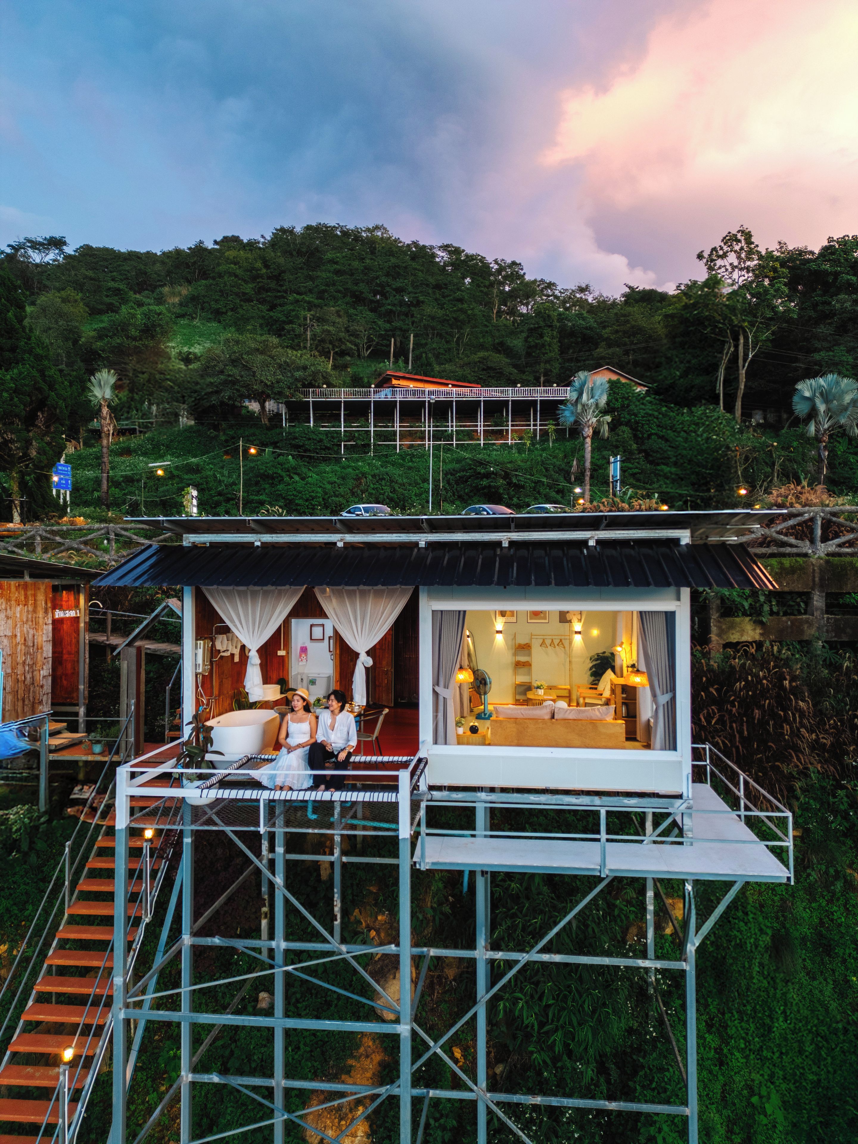 A bungalow with a balcony, a large bathtub, and a staircase leading to the upper level.