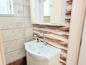 Chuveiro, secador de cabelo, toalhas de banho, shampoo