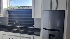 Een moderne keuken met een ingebouwde gootsteen, roestvrijstalen apparatuur en een raam met uitzicht.