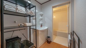 A compact bathroom with a sink, mirror, and towel storage on shelves. - Takayama Stay Karatachi DX-B (Takayama)