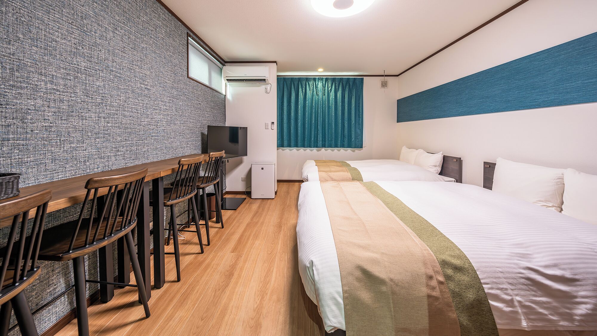 Ein Hotelzimmer mit Schreibtisch, Stühlen, einem Bett und einem Fernseher.