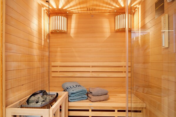 Una sauna con pareti in legno, una panca e asciugamani.