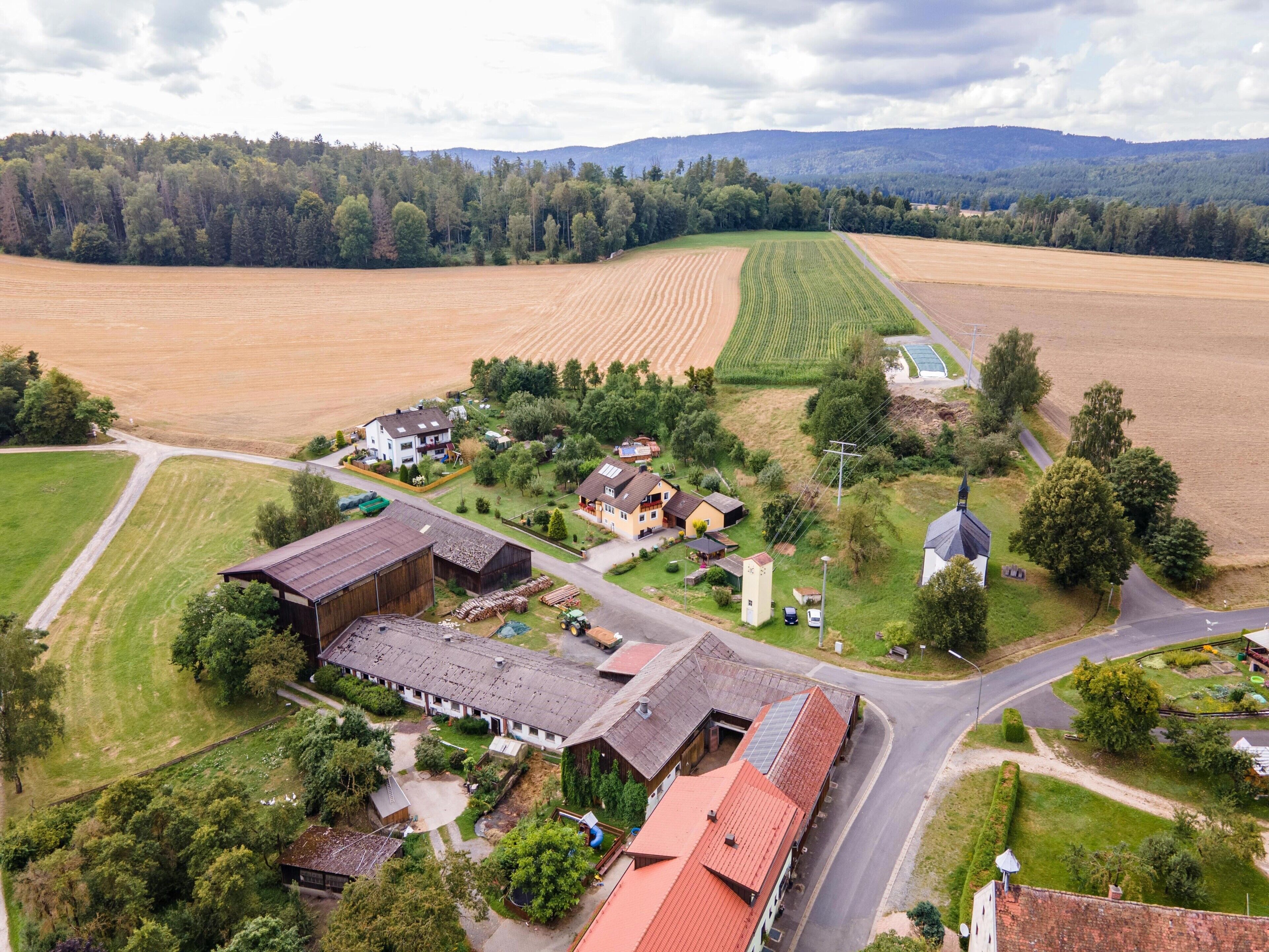 Une vue aérienne d’un village rural avec ses champs, ses maisons et son église.