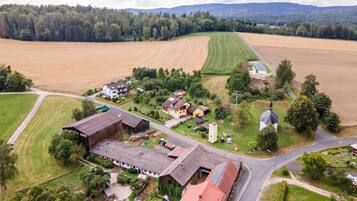 Une vue aérienne d’un village rural avec ses champs, ses maisons et son église.