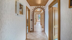 A hallway with wooden ceiling, tiled floor, and a brick archway. - Apartment 'Ferienwohnung Bächer' with Shared Garden, Balcony and Wi-Fi (Wiesau)