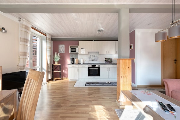 A modern kitchen with white cabinets, a microwave, and a central island.