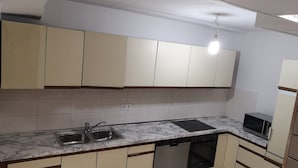 A kitchen with white cabinets, a marble countertop, a dishwasher, and a microwave. - Apartment in Krumbach with Shared Terrace (Krumbach (Schwaben))