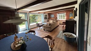 A spacious living area with a dining table, sofa, and a television.