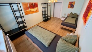 Une chambre comprenant un lit, un coin salon, une armoire et des œuvres d’art accrochées aux murs.