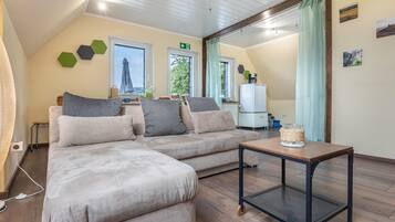 Ein modernes Wohnzimmer mit einer Eckcouch, einem Couchtisch und Blick ins Freie.