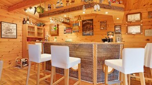 A wooden bar area with stools, shelves with bottles, and maritime-themed decorations. - Apartment 'Offenbüttel' with Private Terrace, Shared Garden and Wi-Fi (Offenbüttel)