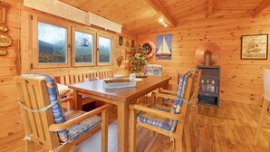 A wooden cabin interior with a dining table, chairs, a fireplace, and nautical-themed decorations. - Apartment 'Offenbüttel' with Private Terrace, Shared Garden and Wi-Fi (Offenbüttel)