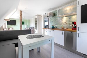 Une cuisine moderne dotée d’un plan de travail en bois, d’appareils électroménagers en acier inoxydable et d’un four encastré.