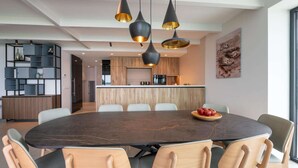 A modern dining area with a round table, chairs, and pendant lighting. - Attractive villa with jetty (Kamperland)