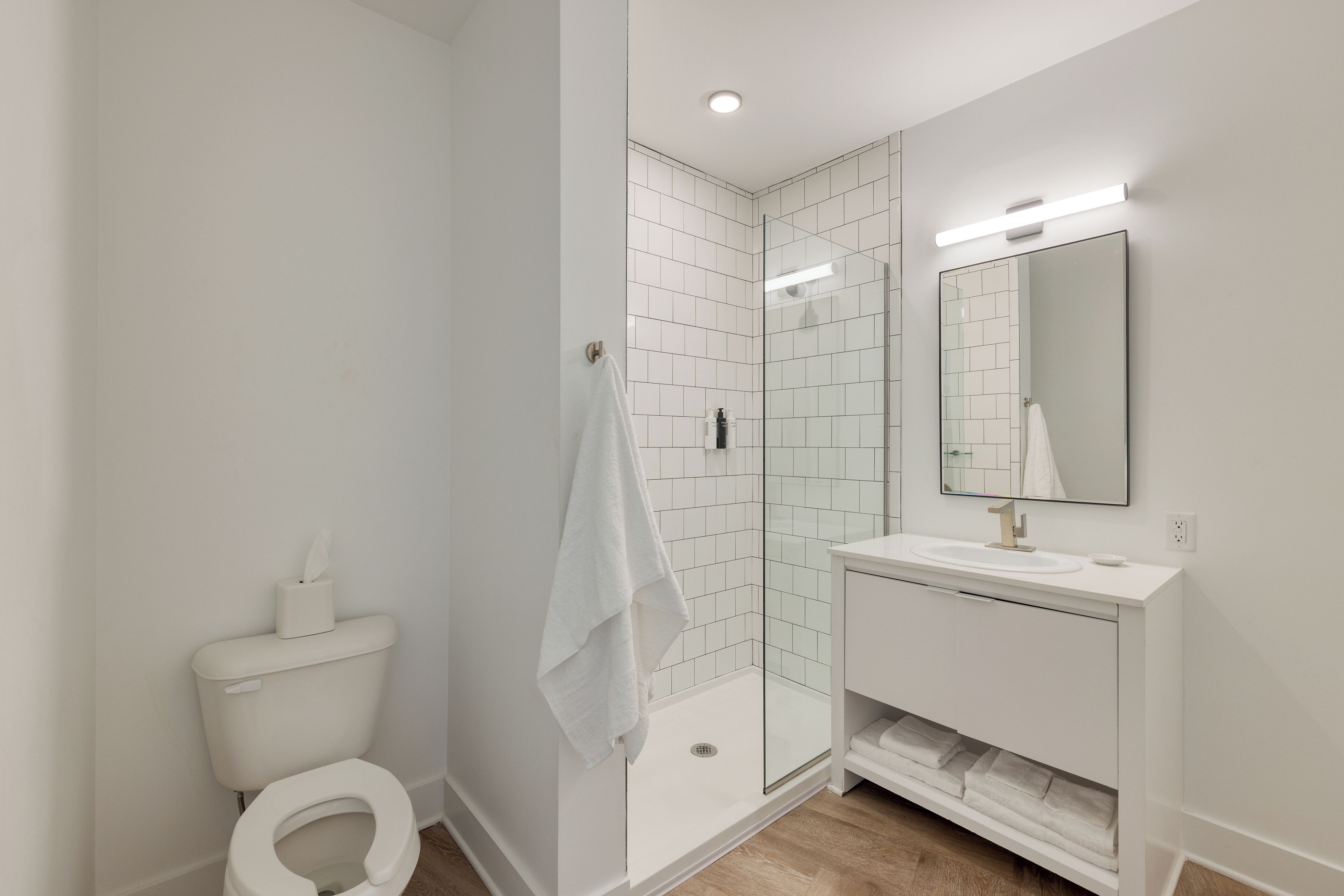 Ein modernes Badezimmer mit Duschkabine, Toilette und Waschtisch mit Spiegel.