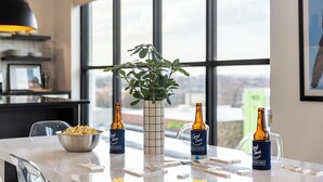 A dining table with a bowl of cereal, two bottles of beer, and a potted plant. - Bachelor Party Pad, 5 Minutes to Broadway + Private Balcony | Last Call (Nashville)