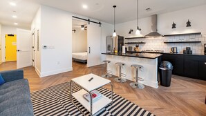 Un apartamento moderno con cocina, sala de estar y un pequeño comedor.
