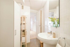 A bathroom with a white sink, a mirror, and a towel rack. - Solaga - Larios Suites (Málaga)
