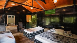 A cozy, rustic bedroom with two beds, a wooden ceiling, and a small seating area. - Ella Deck Resort (Ella)