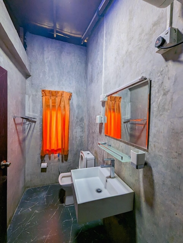 A small, narrow bathroom with a white sink, a mirror, and orange curtains. - Ella Deck Resort (Ella)