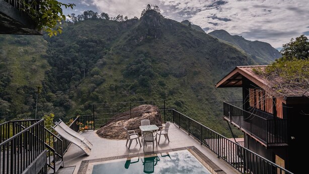 A pool area with a view of a mountainous landscape, surrounded by a wooden structure with a balcony. - Ella Deck Resort (Ella)