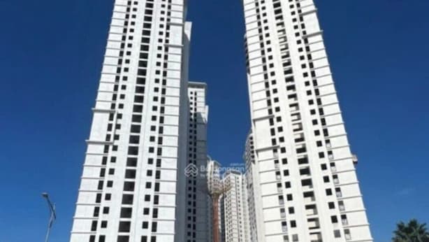 Un immeuble de grande hauteur, composé de plusieurs étages, sur lequel on peut voir un grand panneau « TECCO » bien en évidence au sommet.