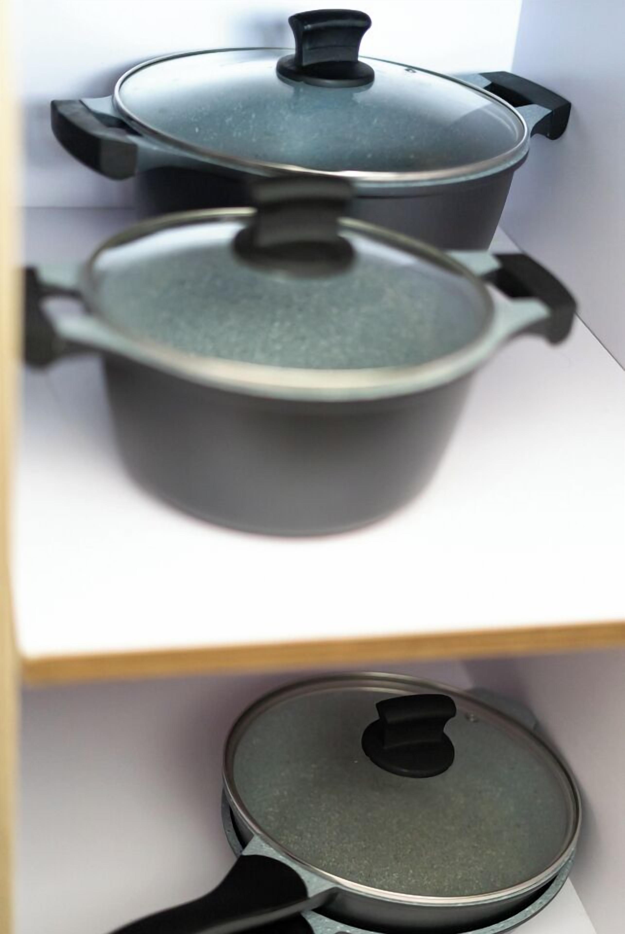 A kitchen with two pots on a shelf.