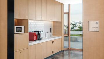 Una cocina moderna con armarios de madera, una encimera blanca y un electrodoméstico rojo.