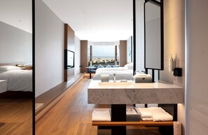 A modern hotel room with a large bed, a bathroom with a marble sink, and a view of the beach. - Fairfield by Marriott Yantai (Yantai)
