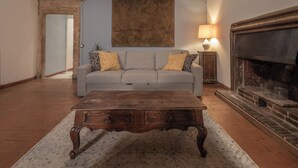 A living room with a sofa, a wooden coffee table, a fireplace, and a painting on the wall. - ROMA TRASTEVERE "SUITE BENEDETTA" (Roma)