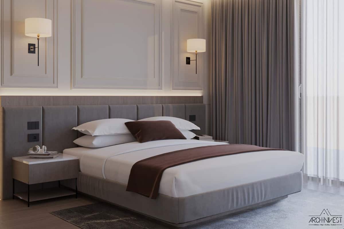 Une chambre d’hôtel moderne avec un grand lit, deux tables de chevet et des lampes fixées au mur.