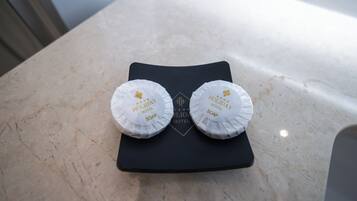 Zwei weiße Seifenstücke mit dem Aufdruck "Holiday Hotel Soap" auf einer schwarzen Ablagefläche.