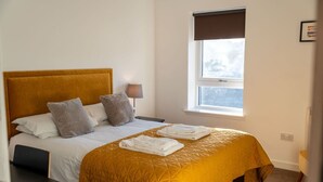 A hotel room with a bed, a window, and a lamp. - Aberlour Apartment No 2 (Argyll and Bute Council)