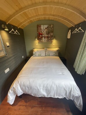 A room with a bed, a painting on the wall, and a wooden ceiling. - Enchanted Cabin Retreat in Sibford Gower (Banbury)