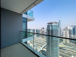 A modern building with a glass balcony overlooking a cityscape with high-rise buildings. - Stylish 2BR with Marina Views (Dubai)